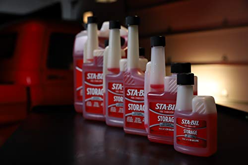 Row of Sta-Bil storage bottles on a wooden surface 