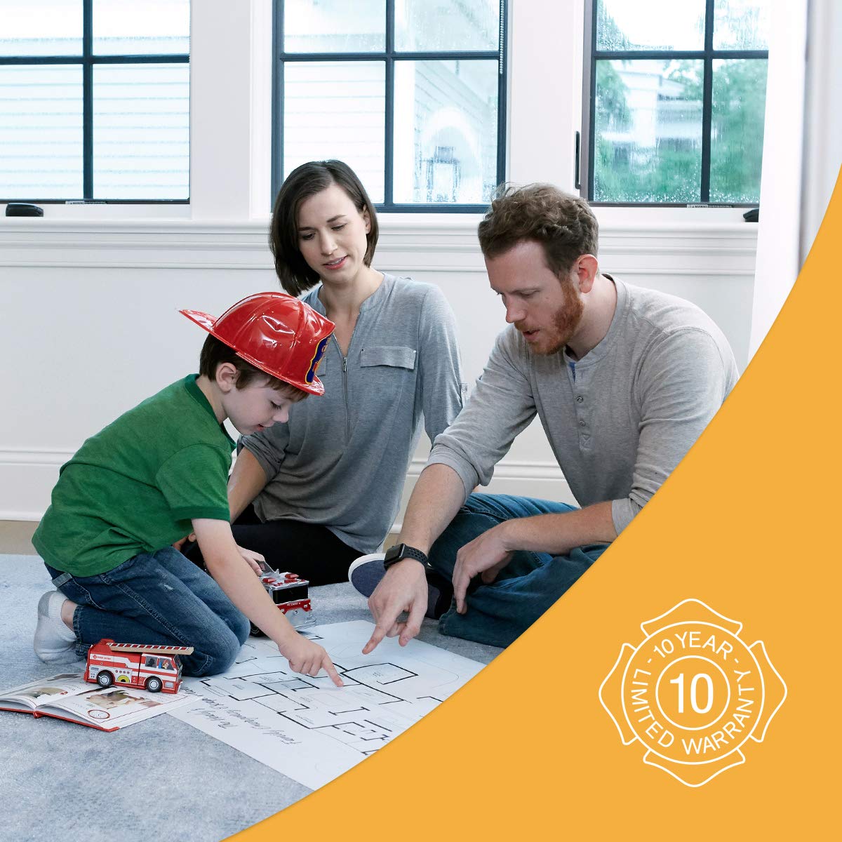 Family looking at blueprints with a child wearing a hard hat, featuring a warranty logo on an orange banner.