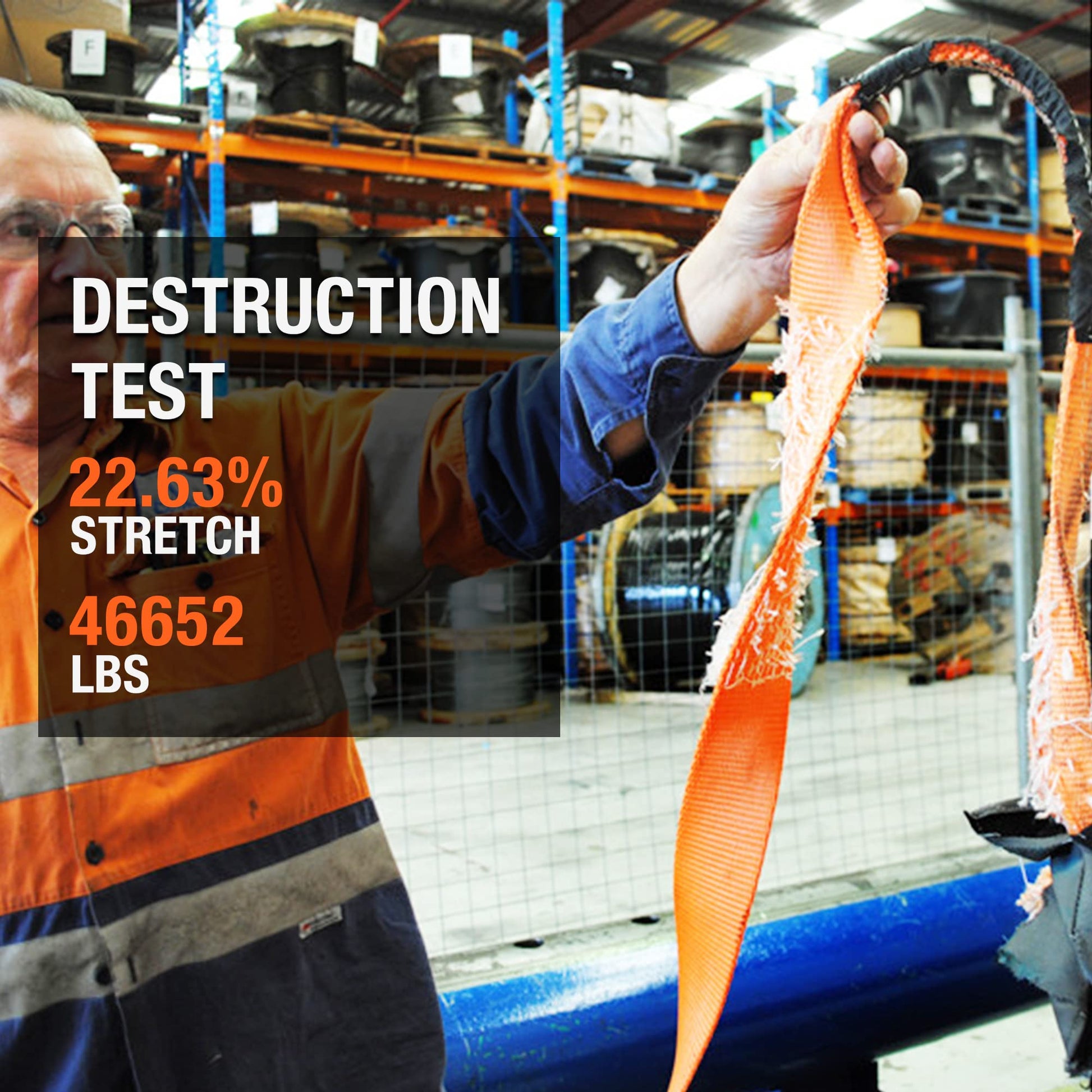 Person holding an orange strap with text about a destruction test in a warehouse setting