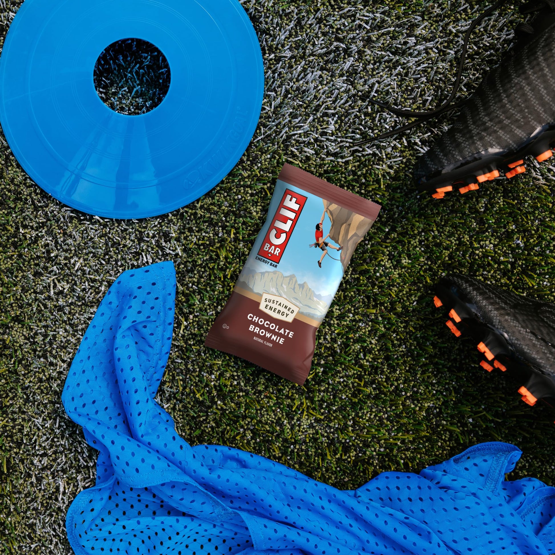 CLIF Bar chocolate brownie energy bar on grass with blue towel and disc.